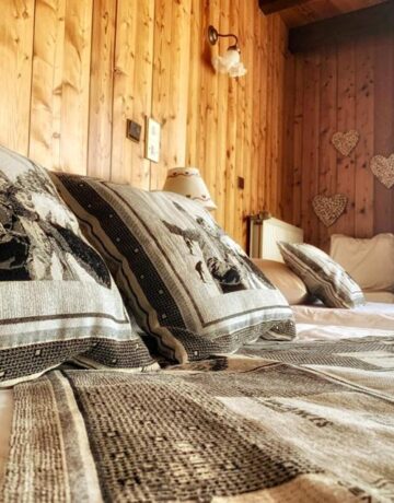 Chambre en bois avec coussins brodés motifs skieurs vintage