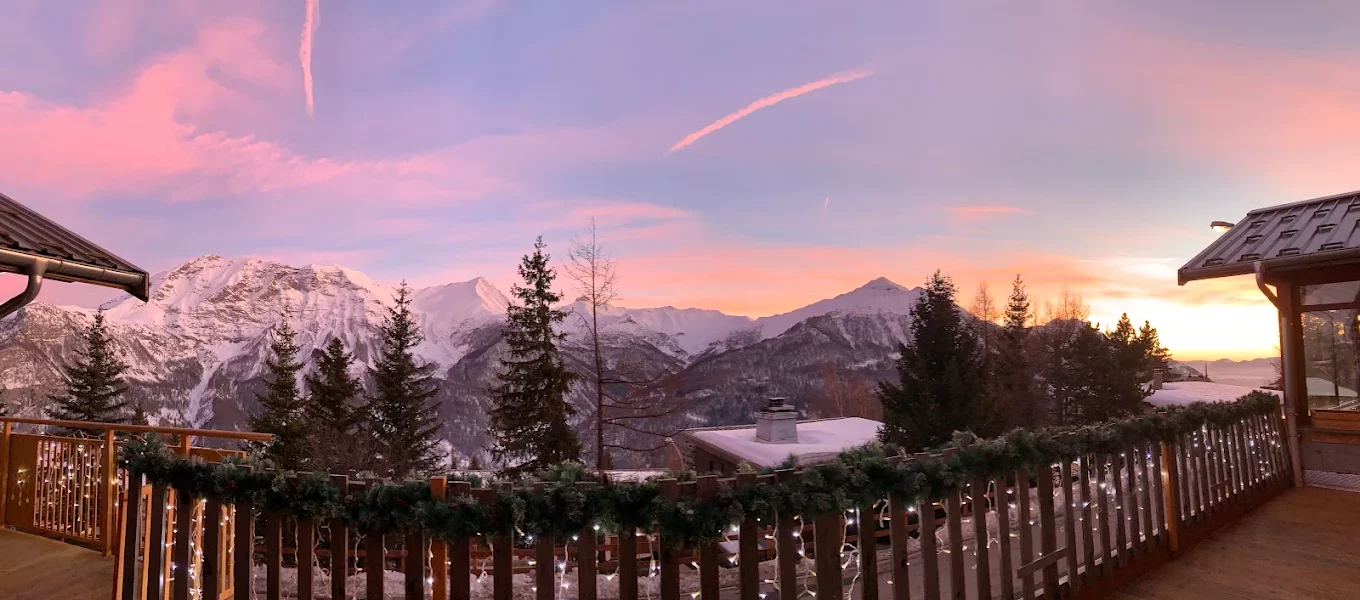 Coucher de soleil sur les montagnes enneigées depuis un balcon