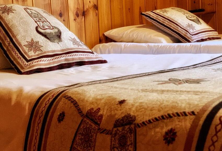 Lits jumeaux avec coussins brodés motif bouquetin