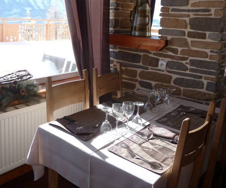 Table dressée en salle de restaurant avec vue sur les montagnes