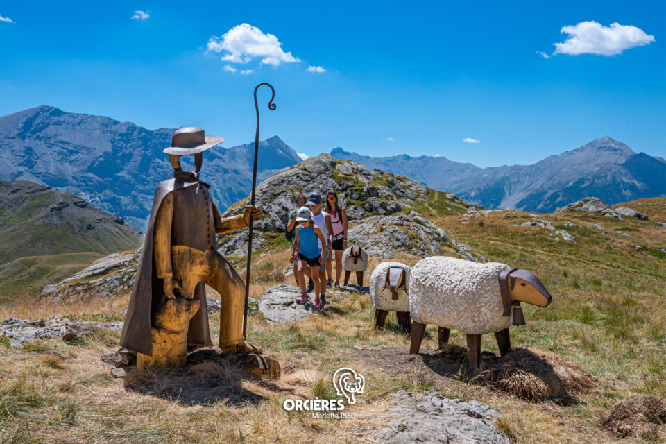 Sculptures de berger et de moutons le long du sentier du Monde des 6 Lacs, avec randonneurs