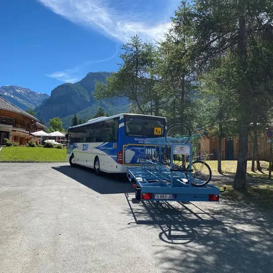 Navette de la station avec remorque à vélos garée devant un chalet en été à Orcières Merlette